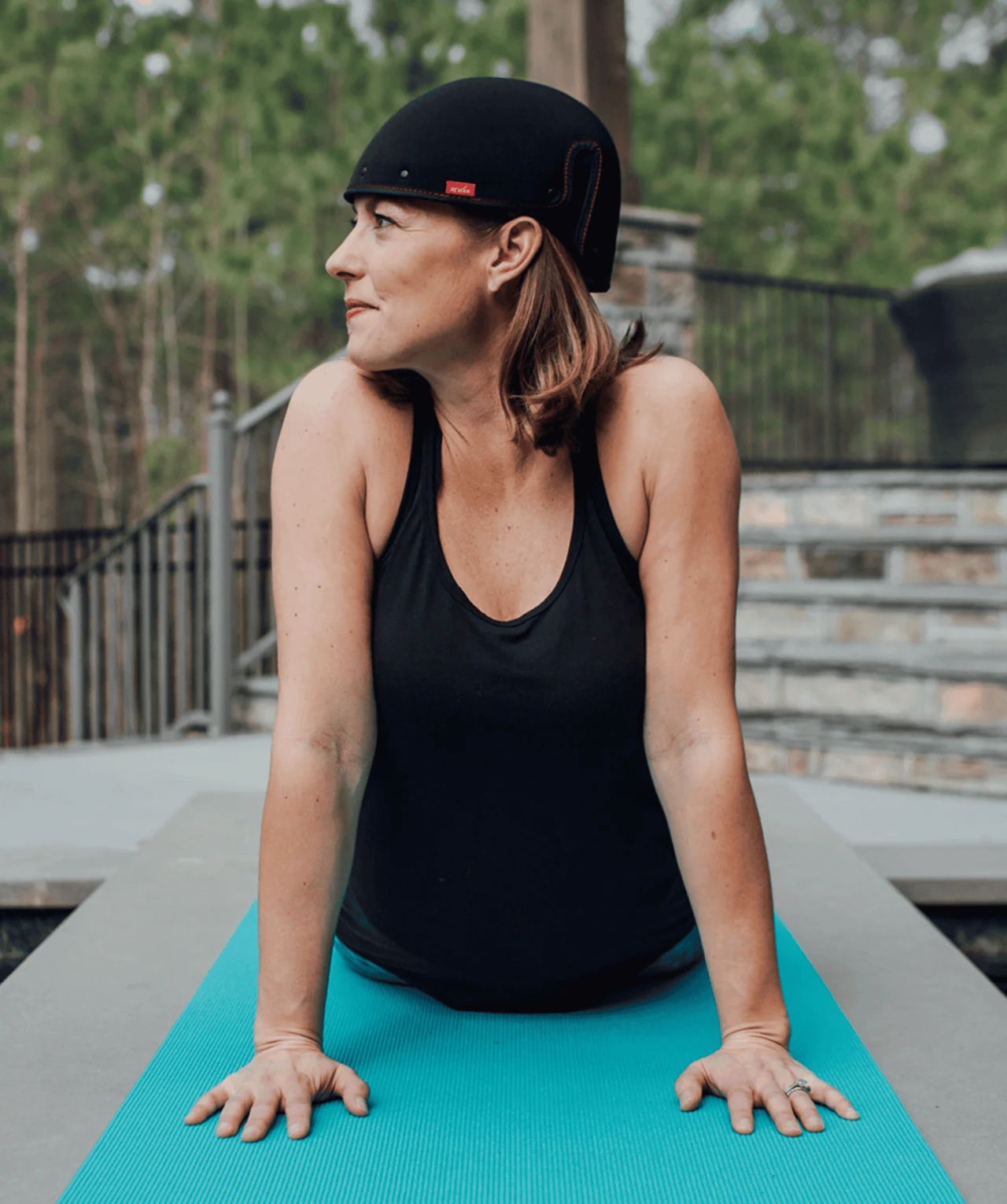 Person practicing yoga while wearing the Revian red light therapy cap for at-home hair restoration